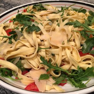 fresh pasta with arugula tomatoes and shaved parmesan