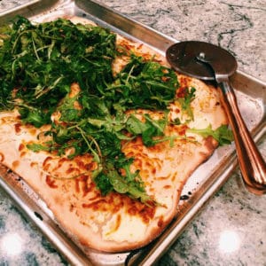 white pizza with arugula salad